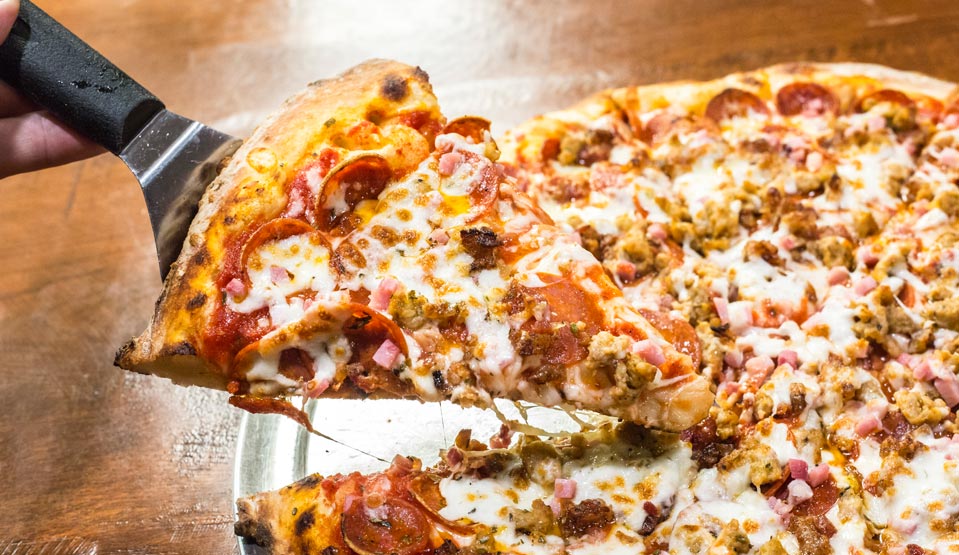 Slice of pizza being pulled from pie.