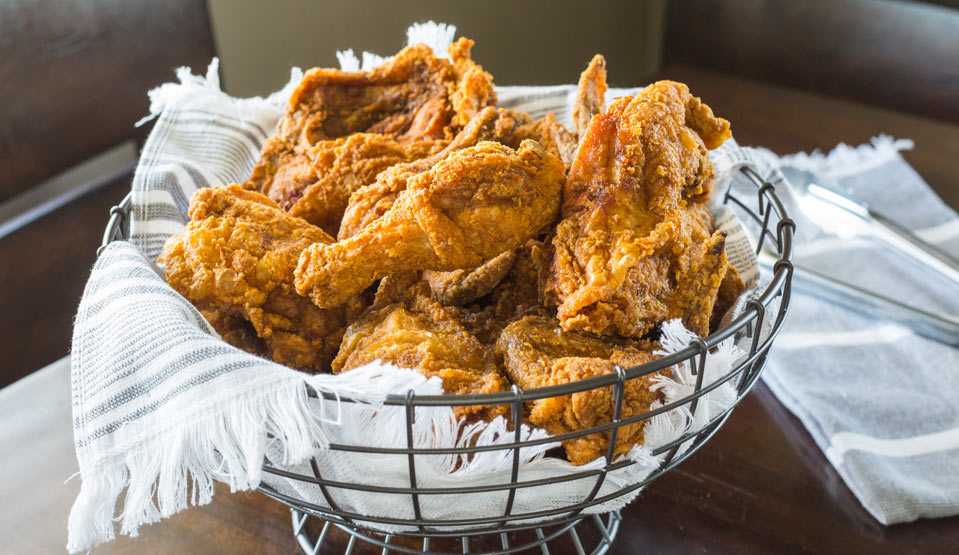 Alabama Fried Chicken on striped white towel in metal wire bowl.