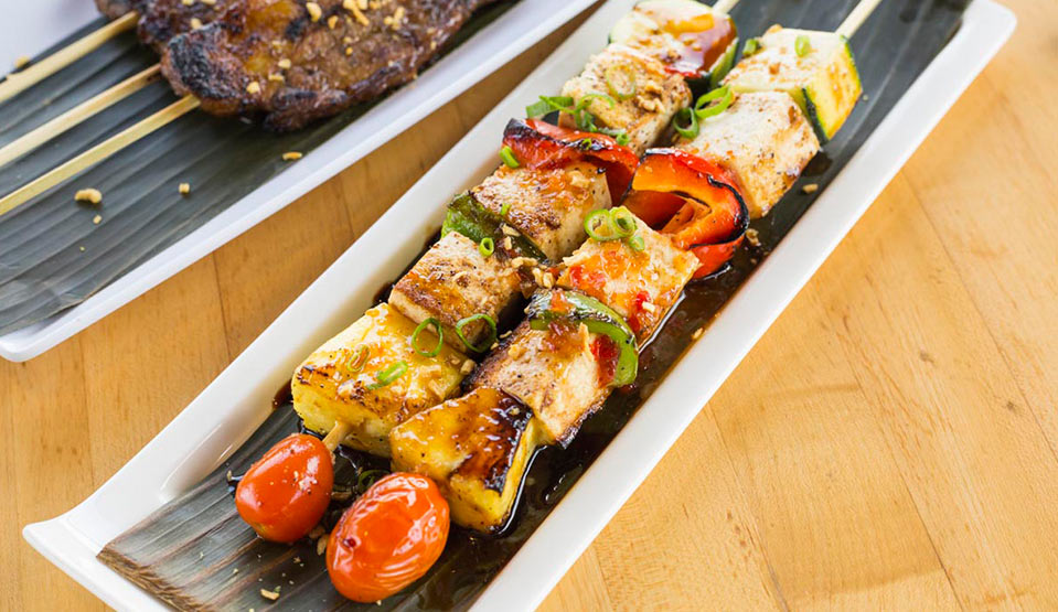 Barbecued meats and veggies skewered and plated.