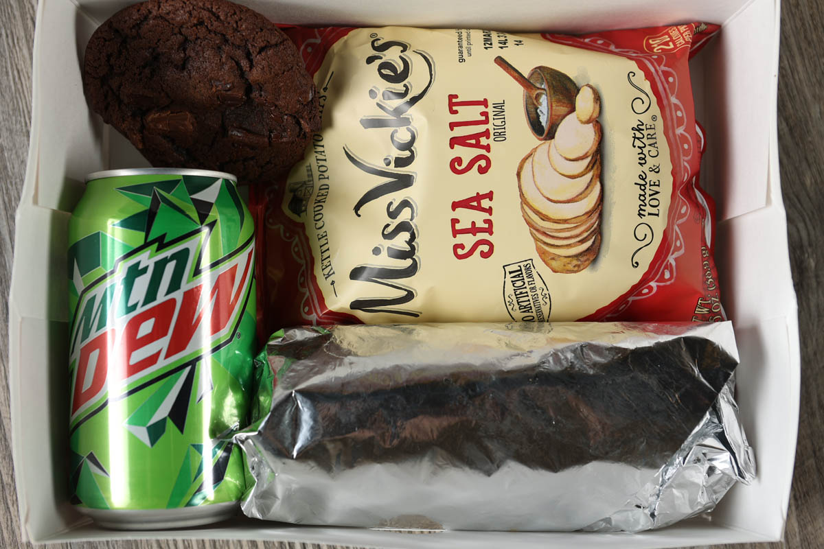 Marlow's Cheesesteaks boxed lunch with chips and can of soda.