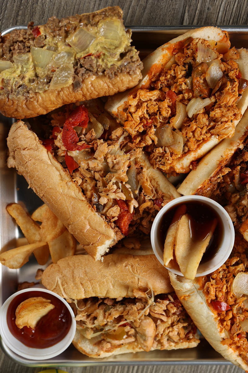 Array of Marlow's Cheeseteaks and fries on a board